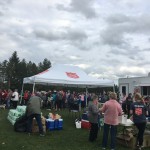 A long line of people to receive food at the park.