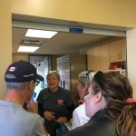 A salvation army volunteer serves people though a window
