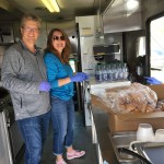 Food service volunteers smile for a photo inside canteen truck